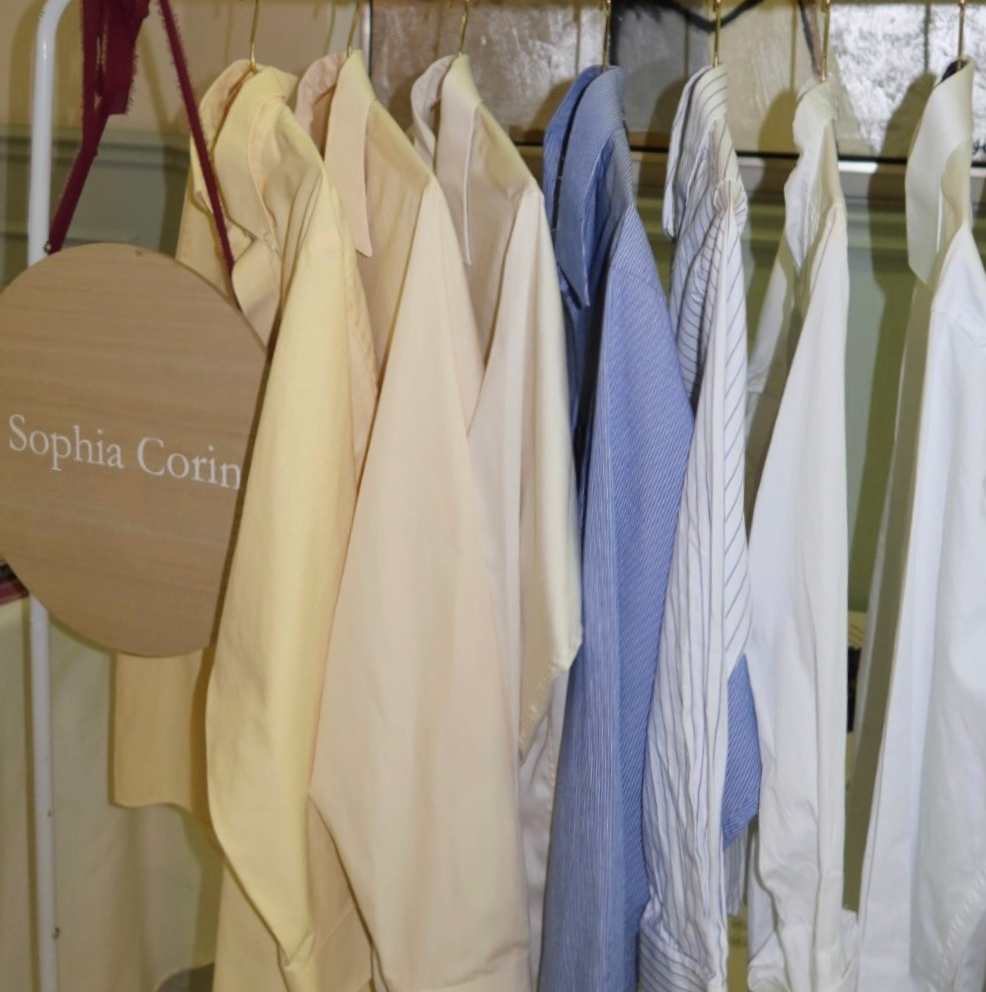 Personalized vintage button up shirts in blue, white, yellow and pinstripe hanging on a rack