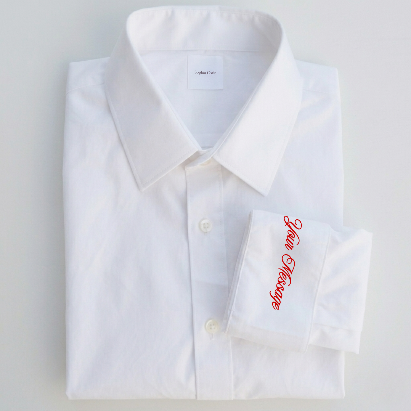 White dress shirt with red embroidery on a light gray background