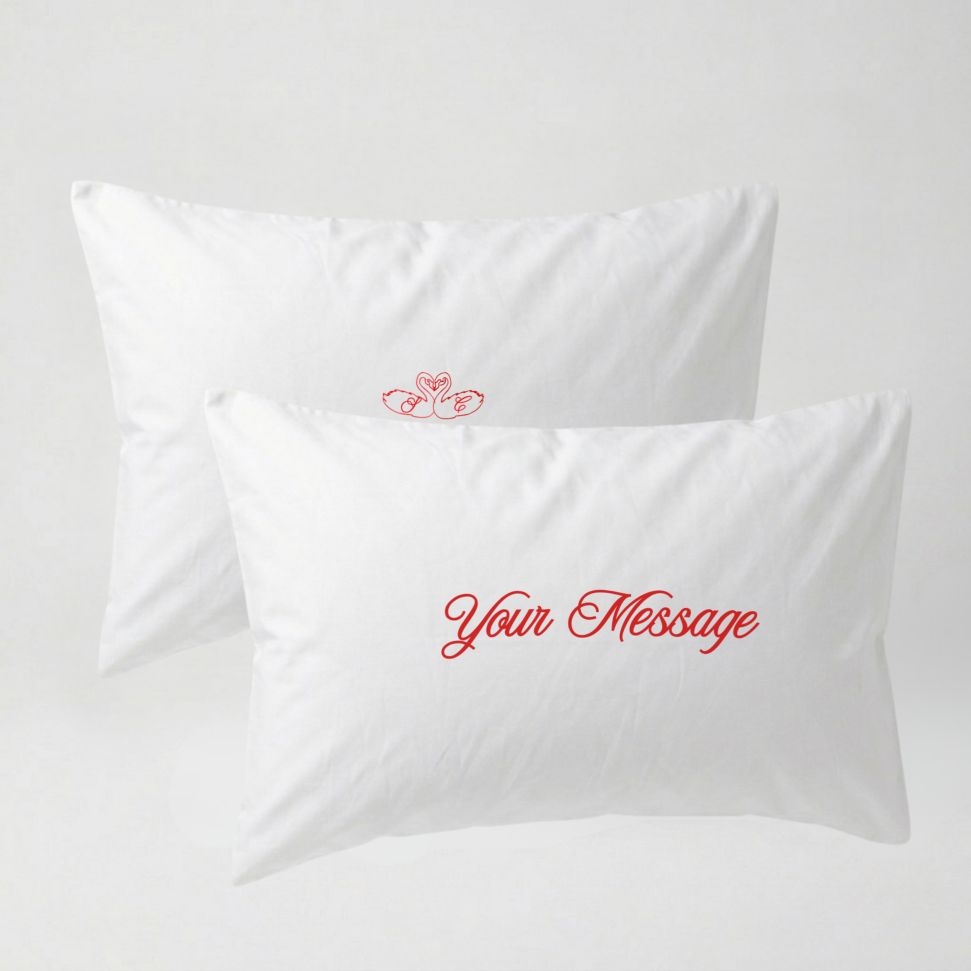Two white pillows with red text on a light gray background