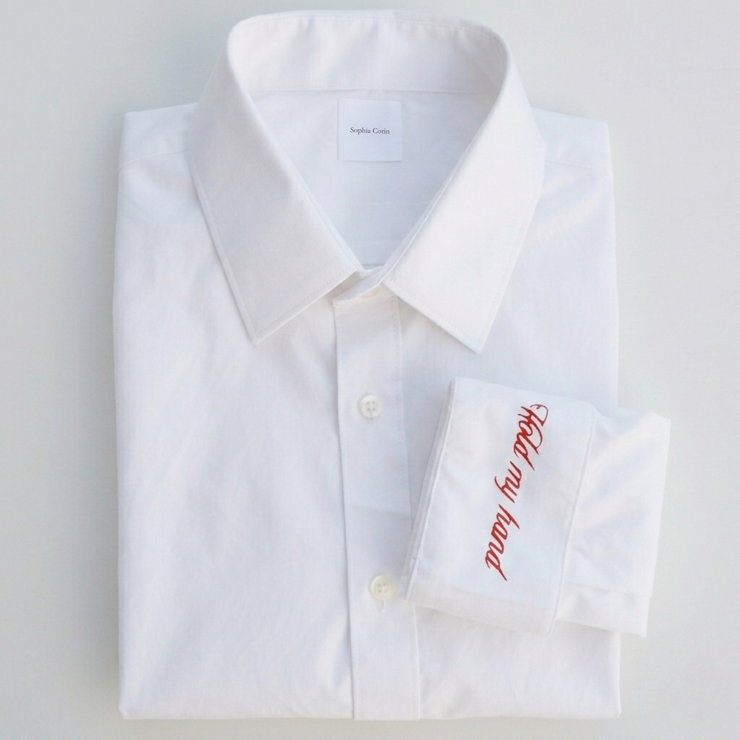 White dress shirt with red text on a light gray background